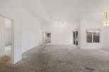 Step into this bright and airy living space, featuring a vaulted ceiling that enhances the sense of openness.