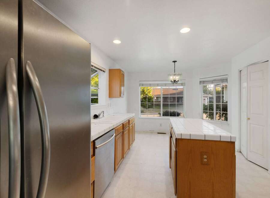 Step into this bright and inviting kitchen, featuring stainless steel appliances and ample cabinet space.