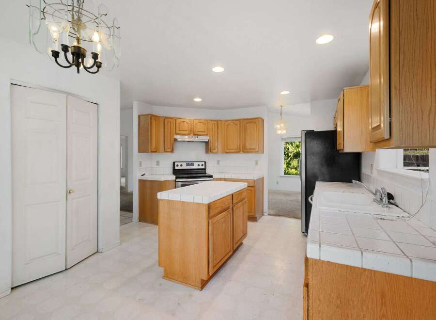 Step into this inviting kitchen, featuring warm wooden cabinetry and ample counter space.