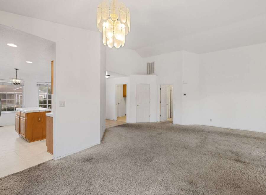 Step into this inviting home featuring a spacious living area with a neutral color palette and plush carpeting.