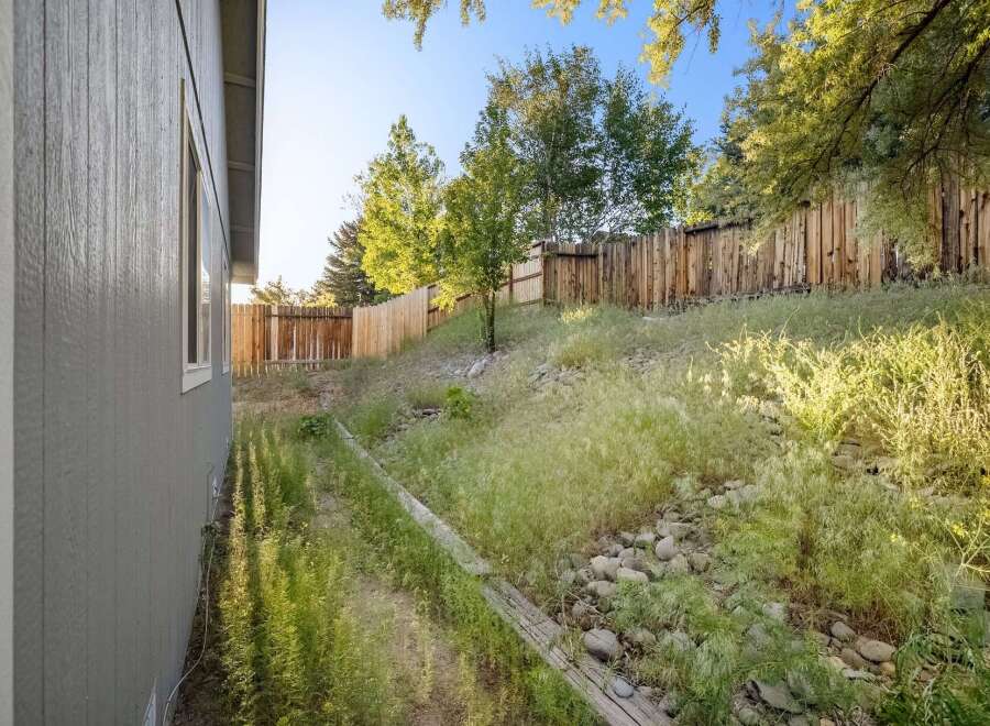 Discover the charm of this property, featuring a beautifully landscaped backyard with a wooden fence.
