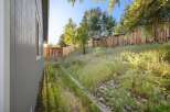 Discover the charm of this property, featuring a beautifully landscaped backyard with a wooden fence.
