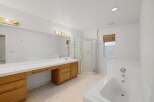 Step into this bright and airy bathroom, featuring a spacious vanity with ample storage and a large mirror.