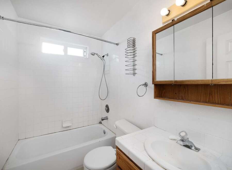 This charming bathroom features a classic design with white tile and a functional layout.