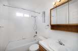 This charming bathroom features a classic design with white tile and a functional layout.