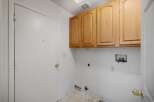 This laundry room features ample storage with overhead cabinets, perfect for organizing cleaning supplies.