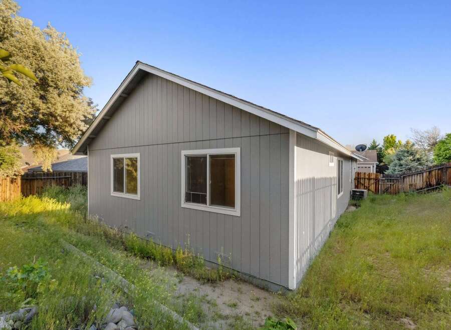 This charming property boasts a well-maintained exterior with a fresh coat of gray paint and crisp white trim.