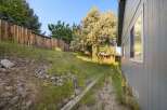 Discover the charm of this property, featuring a serene backyard with a wooden fence and lush greenery.