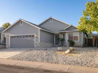 This charming home features a beautiful exterior with a stone facade and a well-maintained yard.