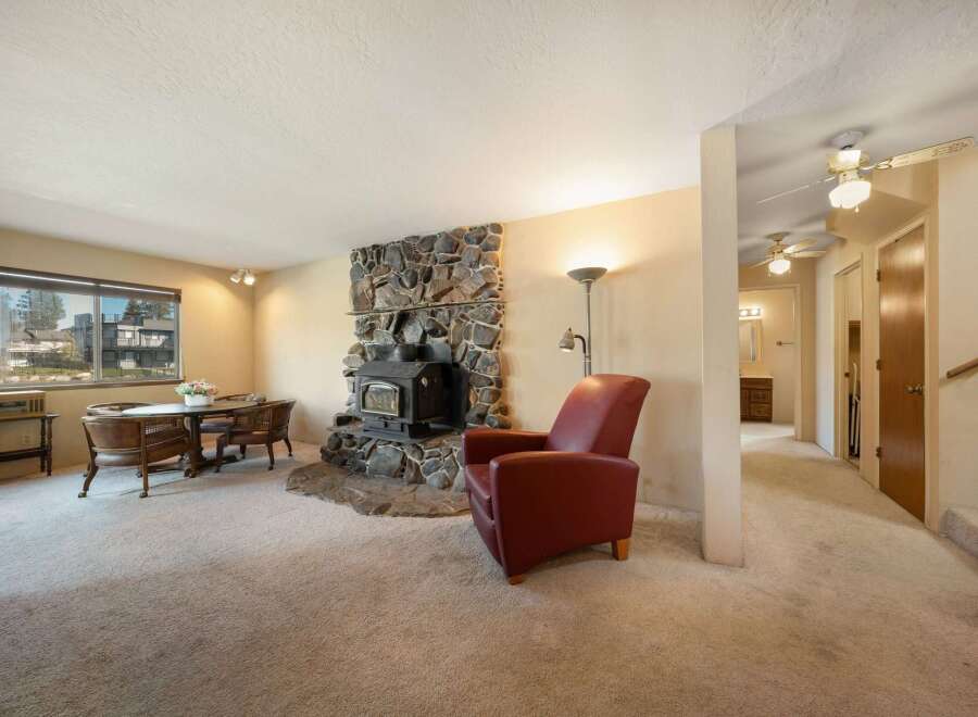 Cozy up in this charming living space featuring a stunning stone fireplace, perfect for those chilly evenings.