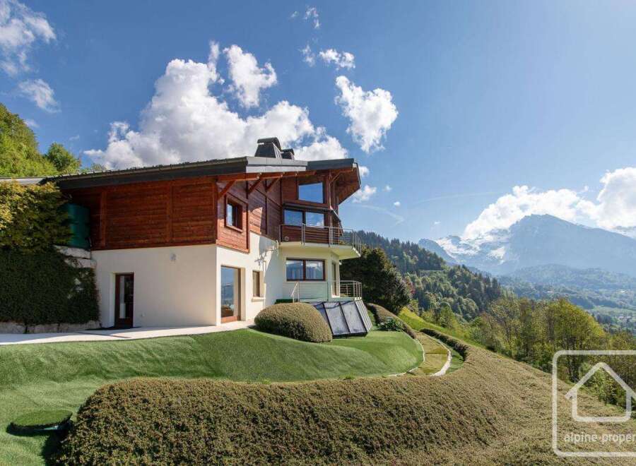 Discover your dream alpine retreat! This stunning property boasts a modern design with a warm wooden facade, offering breathtaking mountain views.