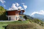 Discover your dream alpine retreat! This stunning property boasts a modern design with a warm wooden facade, offering breathtaking mountain views.