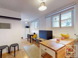 Discover this charming property featuring a cozy living space with a modern TV and a well-equipped kitchen area.