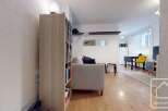 Discover this stylish apartment featuring a cozy living area with a comfortable sofa and a well-stocked bookshelf.