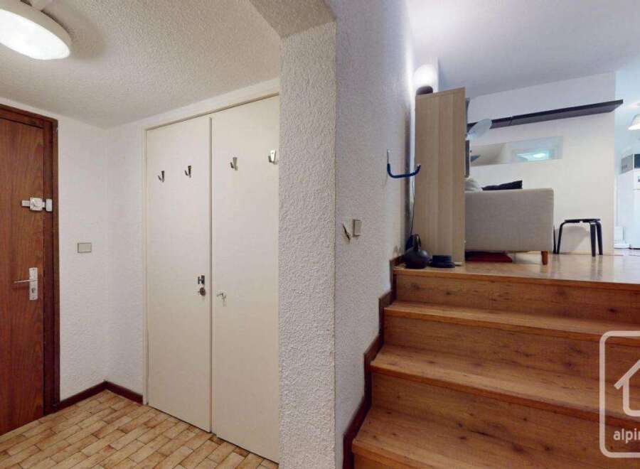 Discover this inviting property featuring a warm wooden staircase leading to the living area.