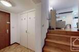 Discover this inviting property featuring a warm wooden staircase leading to the living area.