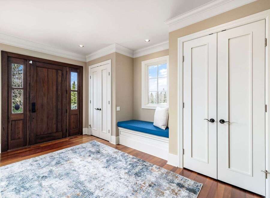Step into luxury with this stunning entryway! Featuring a beautiful wooden door with glass panels, this space exudes warmth and elegance.