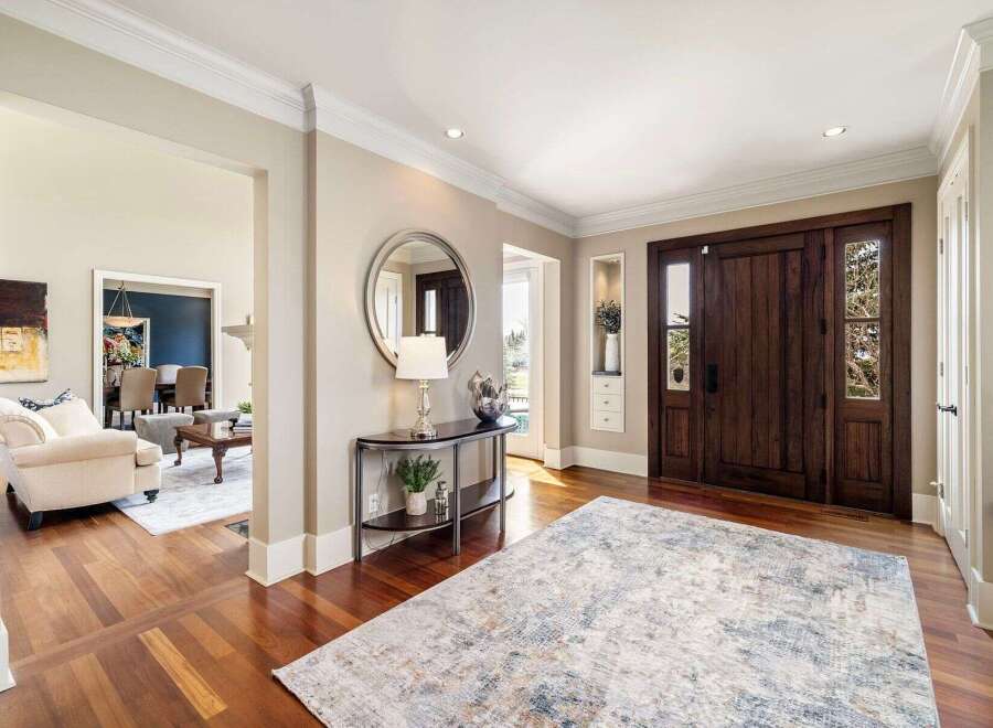 Step into luxury with this stunning entryway! Featuring rich hardwood floors, a stylish console table, and a large area rug, this space exudes elegance.