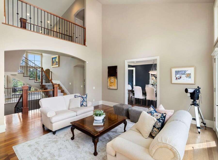 This stunning property boasts a grand entrance with a sweeping staircase and a spacious living area.