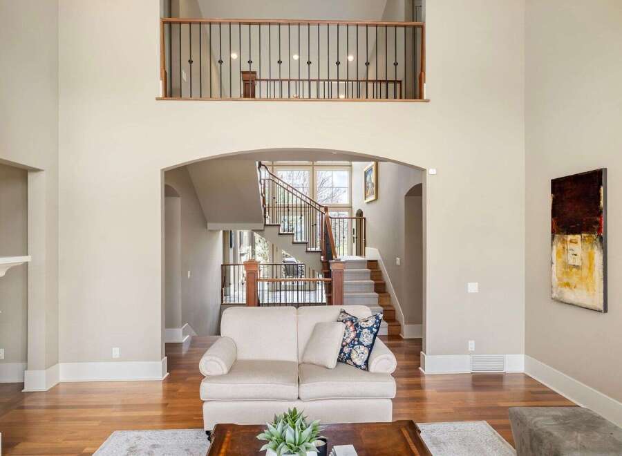 Step into luxury with this stunning property featuring a grand staircase and an open-concept living area.