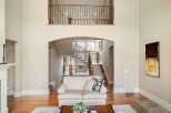 Step into luxury with this stunning property featuring a grand staircase and an open-concept living area.