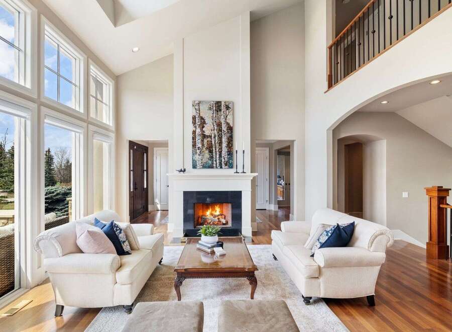 Experience luxury living in this stunning property featuring a grand fireplace, soaring ceilings, and an abundance of natural light.