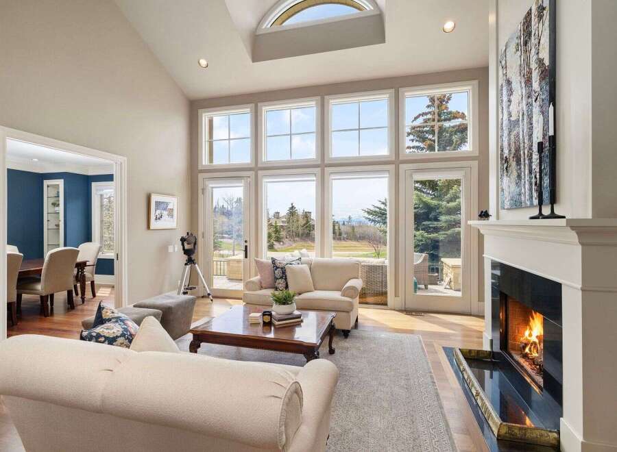 Experience luxury living in this stunning property, featuring a bright and airy living room with expansive windows that flood the space with natural light.