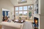 Experience luxury living in this stunning property, featuring a bright and airy living room with expansive windows that flood the space with natural light.