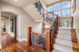 This stunning property boasts a grand staircase with elegant wooden accents and intricate wrought iron railings.