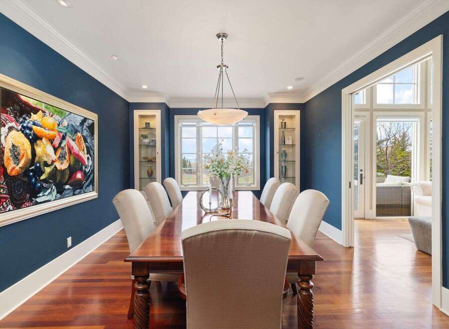 Step into luxury with this stunning dining room, featuring a large wooden dining table and elegant chairs, perfect for hosting gatherings.