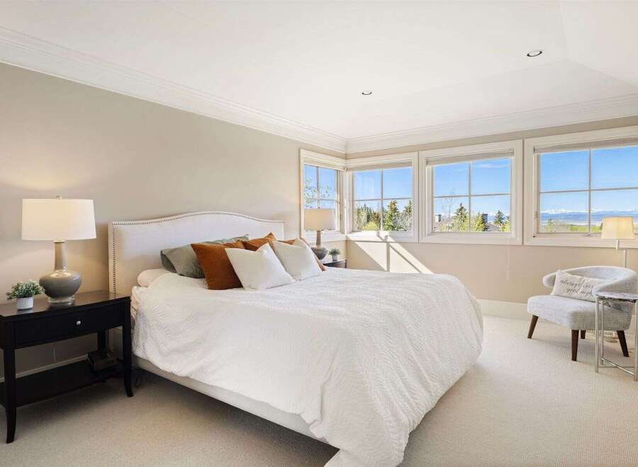Experience luxury in this stunning bedroom, featuring a plush bed and ample natural light.