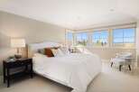 Experience luxury in this stunning bedroom, featuring a plush bed and ample natural light.