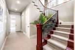 This stunning property features a grand staircase with elegant wooden accents and wrought iron railings.