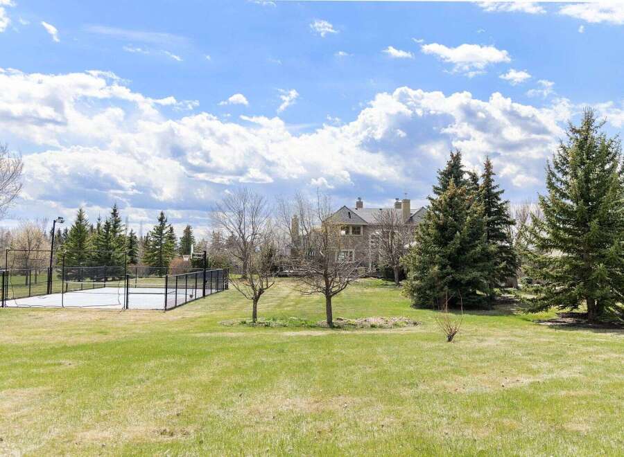 Discover luxury living at this stunning property, featuring a private tennis court and expansive green spaces.