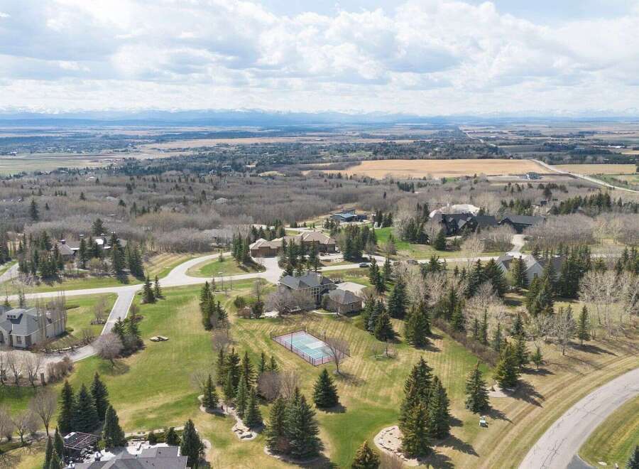 Discover luxury living in this stunning property, showcasing a meticulously maintained landscape and a private tennis court.