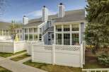 Discover this charming townhome featuring a beautiful exterior with a light blue siding and a white fence.