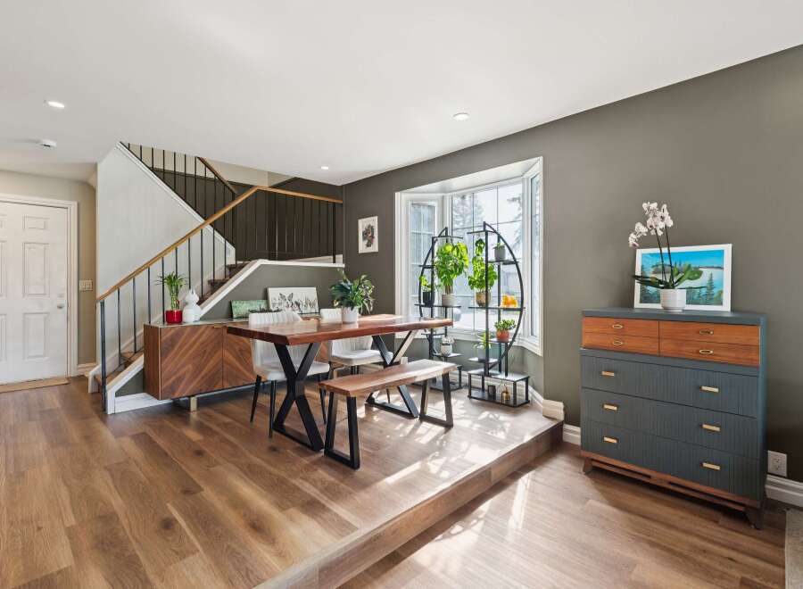 Step into this stunning home featuring a modern dining area with a stylish wooden table and bench.