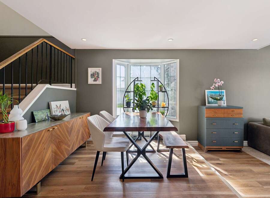 This stunning dining room boasts a modern aesthetic with its sleek wooden flooring and stylish furniture.