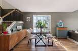 This stunning dining room boasts a modern aesthetic with its sleek wooden flooring and stylish furniture.