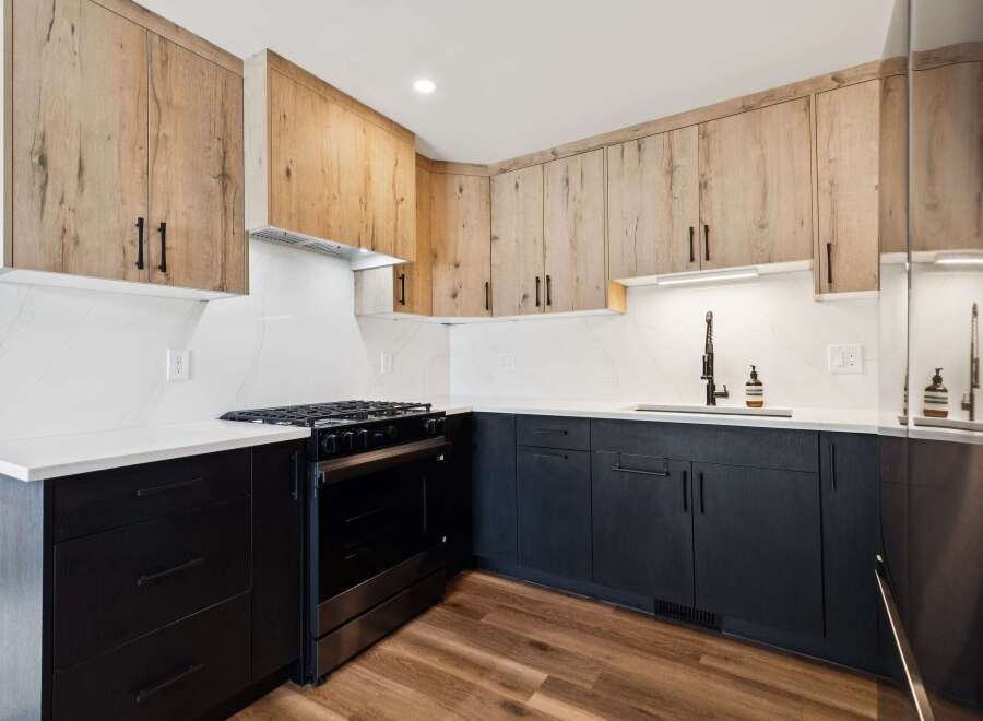 This modern kitchen boasts a sleek design with a combination of light wood and dark cabinetry.