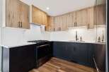 This modern kitchen boasts a sleek design with a combination of light wood and dark cabinetry.
