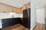 This stunning kitchen boasts modern design with its sleek black cabinetry and elegant wood-toned upper cabinets.