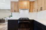 This modern kitchen boasts a sleek design with dark cabinetry and light countertops, creating a striking contrast.