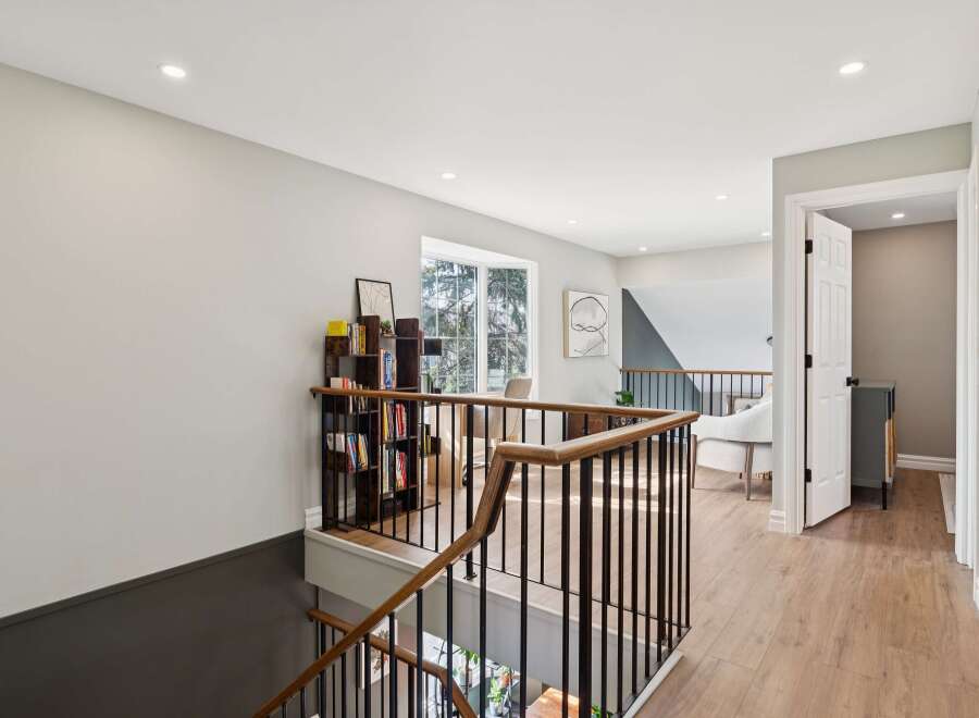 This stunning property features a beautifully designed staircase with a modern railing, leading to a bright and airy hallway.