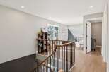 This stunning property features a beautifully designed staircase with a modern railing, leading to a bright and airy hallway.