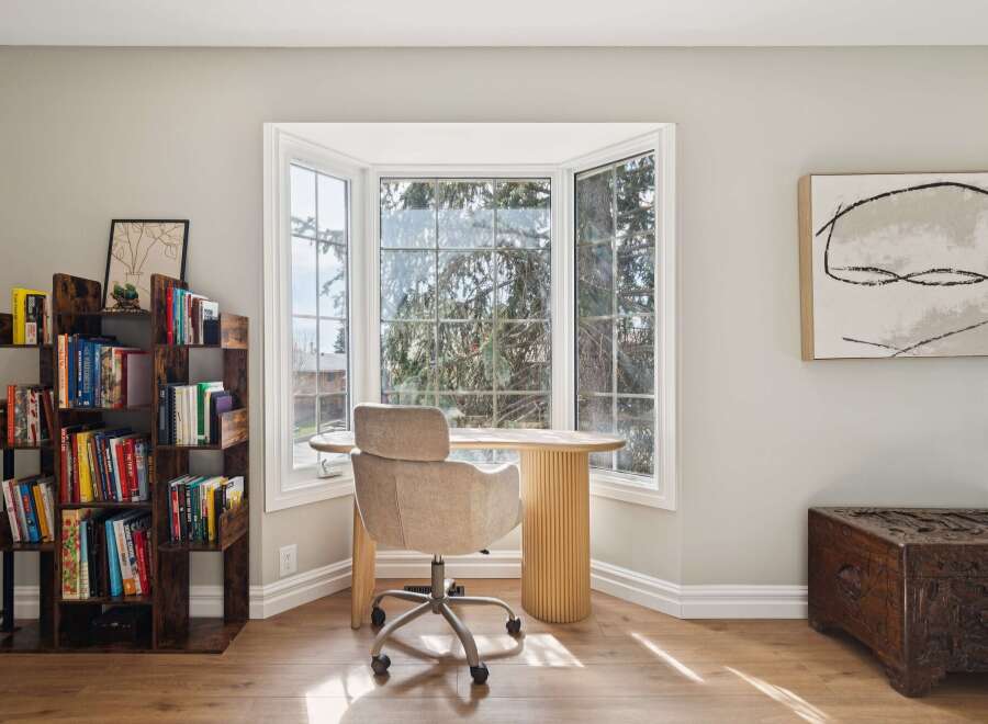 This stunning home office space features a bright, airy design with a large bay window, perfect for natural light and inspiring views.