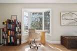 This stunning home office space features a bright, airy design with a large bay window, perfect for natural light and inspiring views.