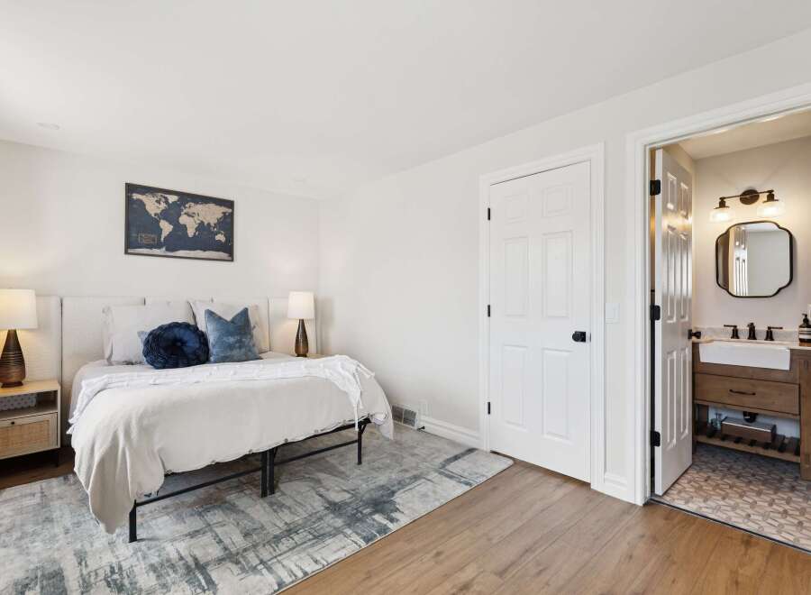 Step into this inviting bedroom, featuring a cozy bed adorned with plush pillows and a stylish rug.