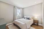 This cozy bedroom features a comfortable bed with soft bedding and decorative pillows, creating a relaxing atmosphere.