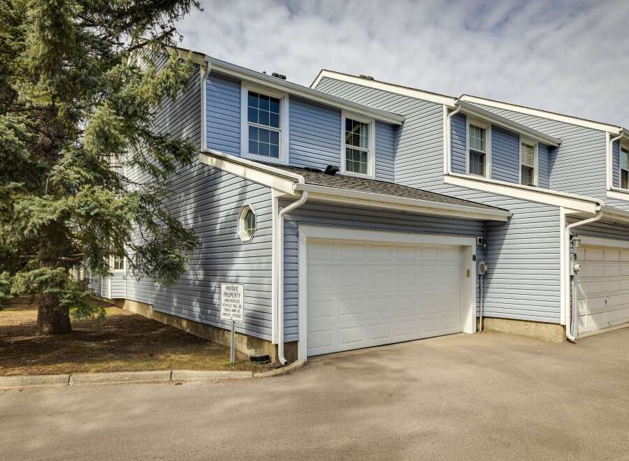 This beautiful property features a modern design with a light blue exterior and a two-car garage.